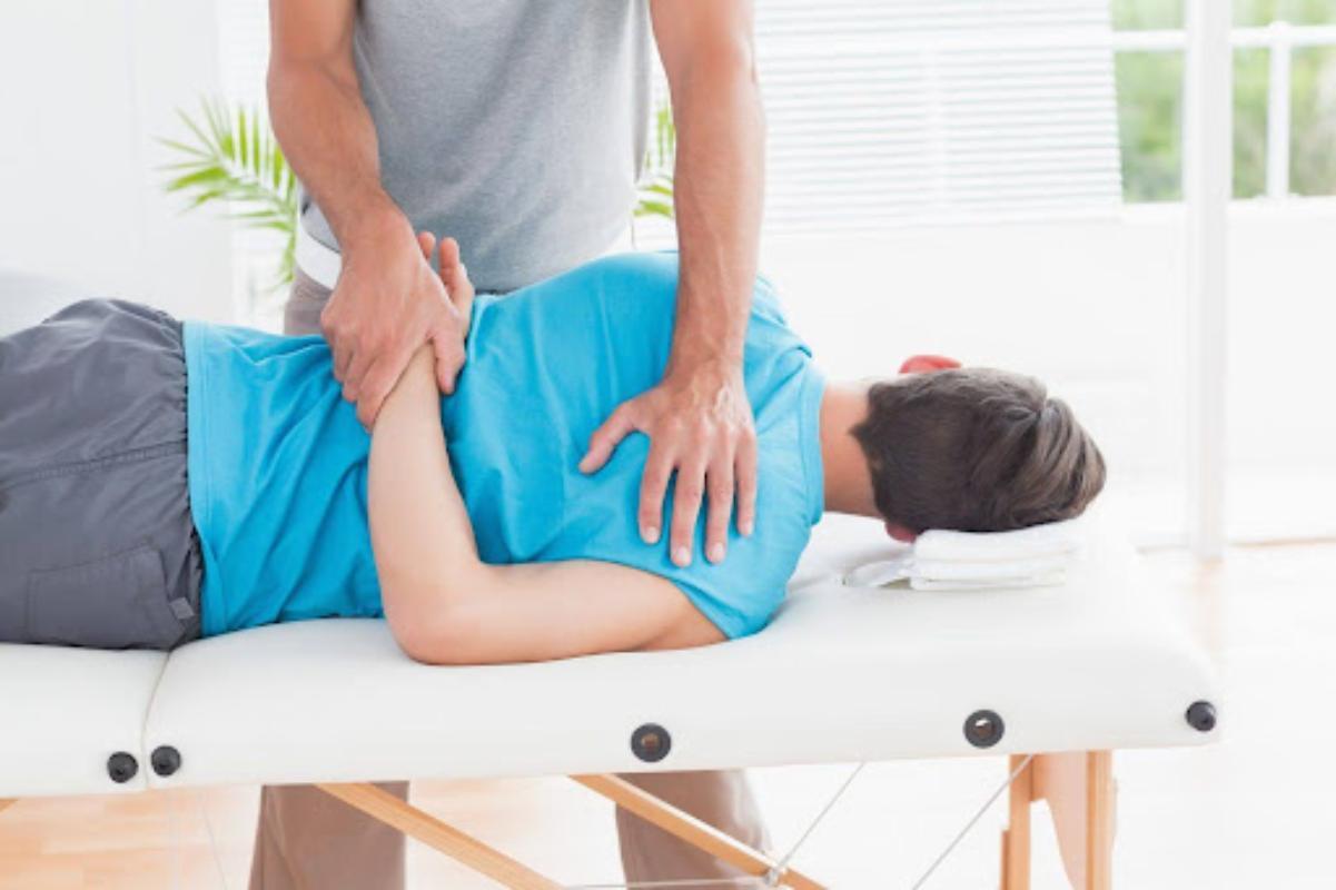 A physiotherapist performs a shoulder stretch to improve mobility and reduce muscle tension for better flexibility